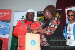 Agatha-Soiltei-from-Occidental-Insurance-Company-presents-Mathews-Mugenya-with-a-gift-hamper-after-the-disability-in-sports-panel-session-as-Henry-Wanyoike-looks-on