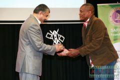 Alfred Njuguna receives a trophy from the acting ambassador of Iran to Kenya HE. Abdul Shaffi Salaam for the Best Short Documentary The Last Trophy.