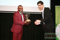 Luke Kizito receives a trophy for Rigert from Reza Khazeni