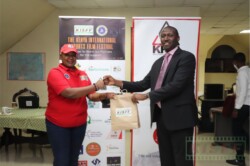 KFCB Acting CEO Christoper Wambua receives a humper from KISFF Marketing director Florence Nduta after the closing ceremony of day one of the festival.